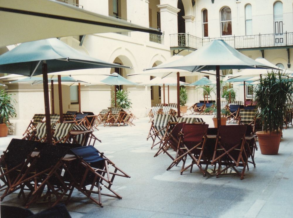 Outdoor dining settings under umbrellas at Jupiters Casino