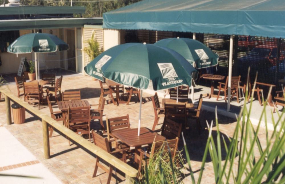 Café tables and chairs on a deck at The Plantation Aquatic Centre