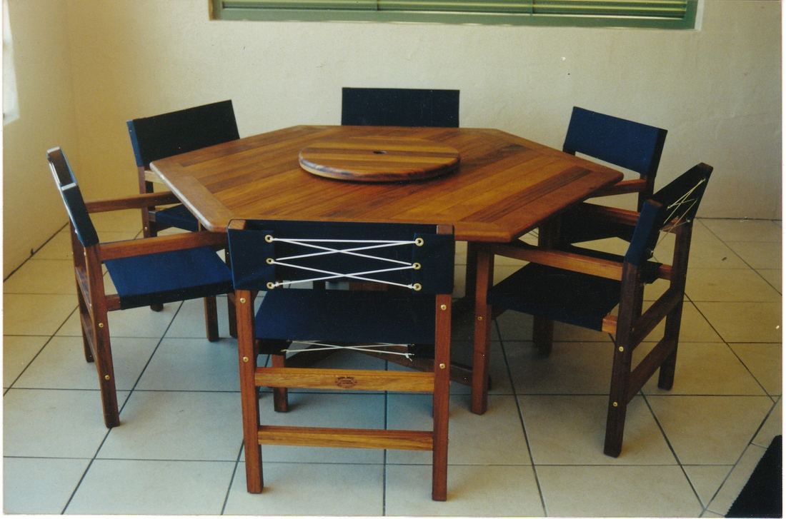 Hexagonal Kwila table with six navy Miami chairs and a lazy Susan