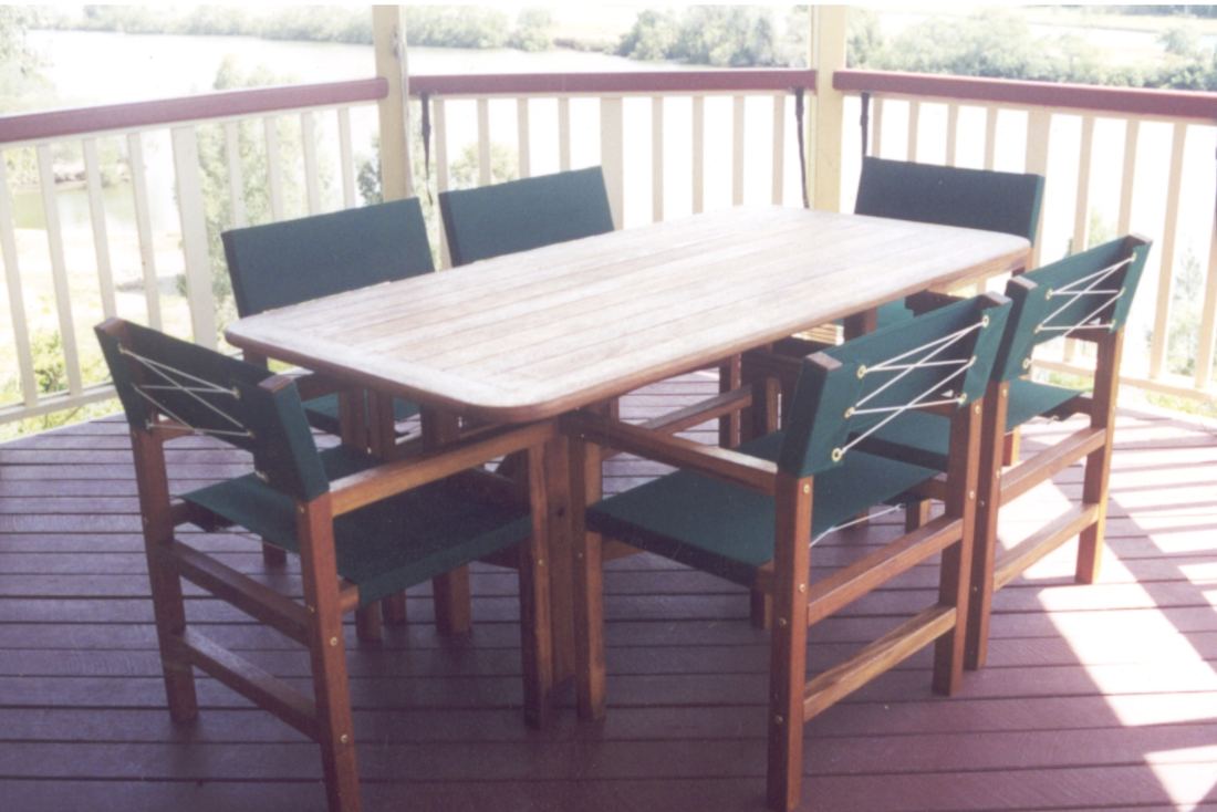 Rectangular Kwila table with green canvas Miami chairs on a verandah