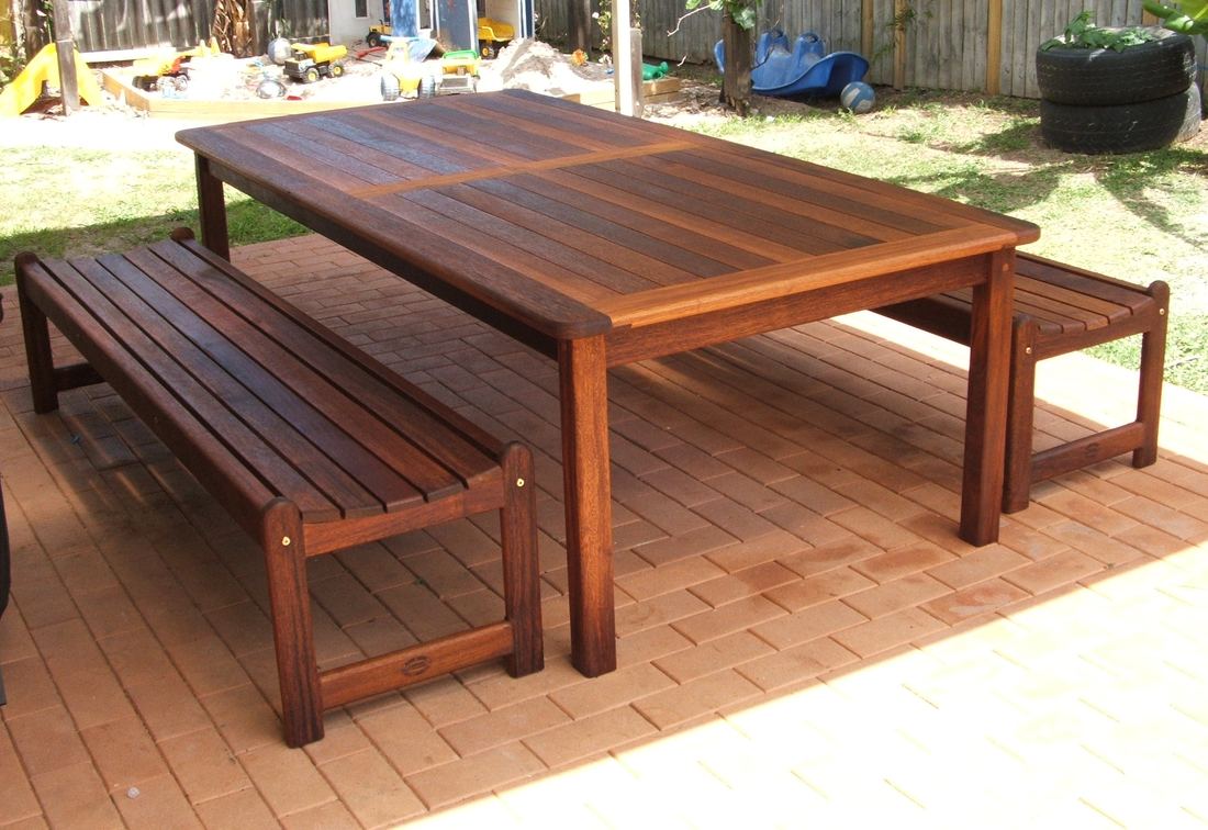Kwila table with two long Kirra benches on a lawn-side deck